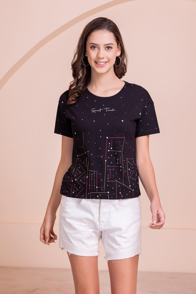 A woman wearing a round neck ,relaxed fit printed cotton top in black Color