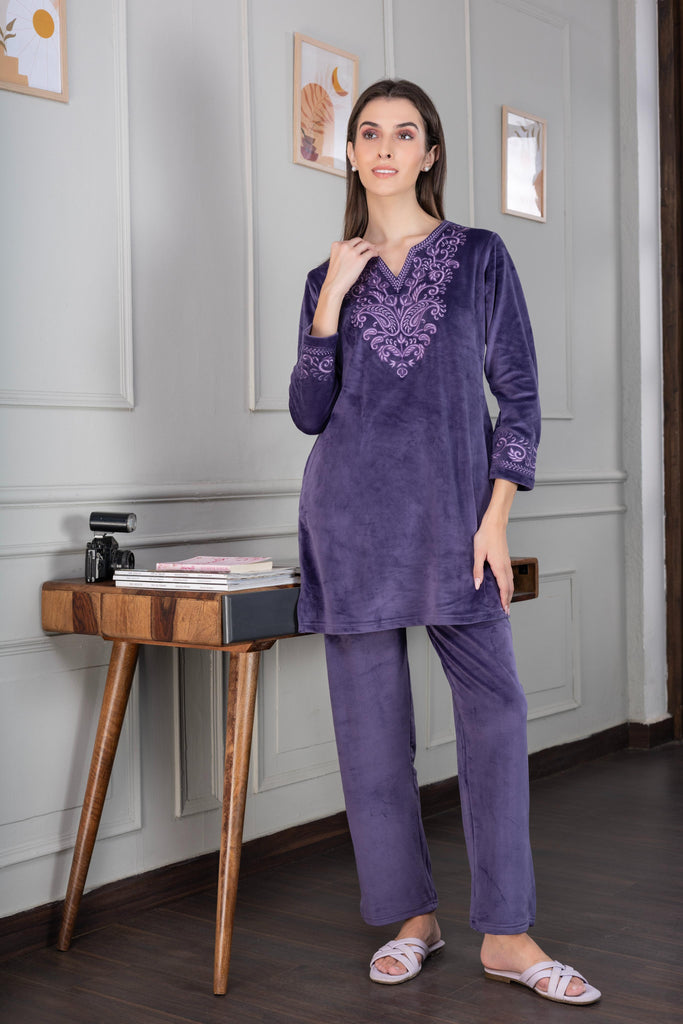 A woman wearing a full sleeve, relaxed fit, Velvet Co-Ord set with V-neck and floral embroidery in purple Color 