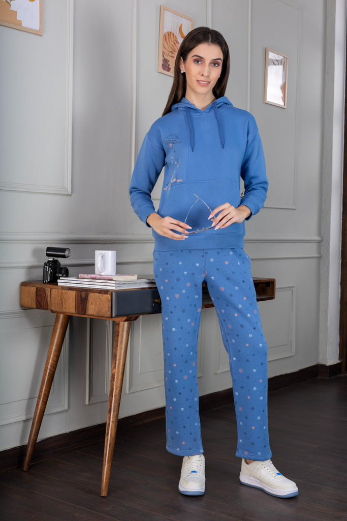 A woman wearing a printed fleece co-ord set with elasticated cuff and hem in sky blue color.