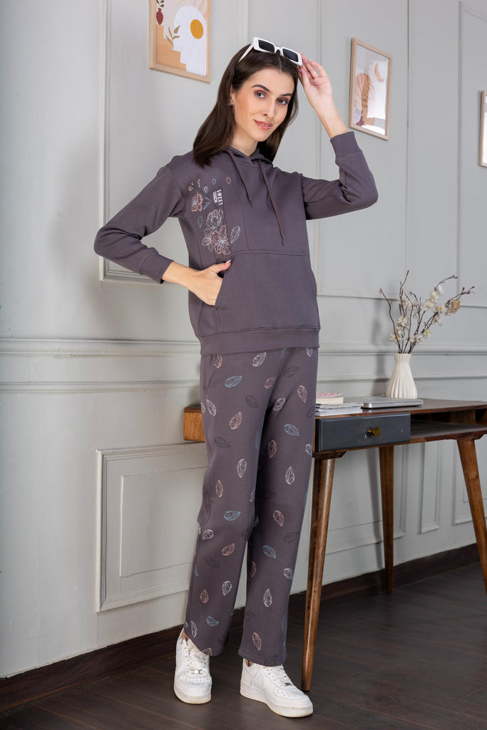 A woman wearing a printed fleece co-ord set with elasticated cuff and hem in grey color.