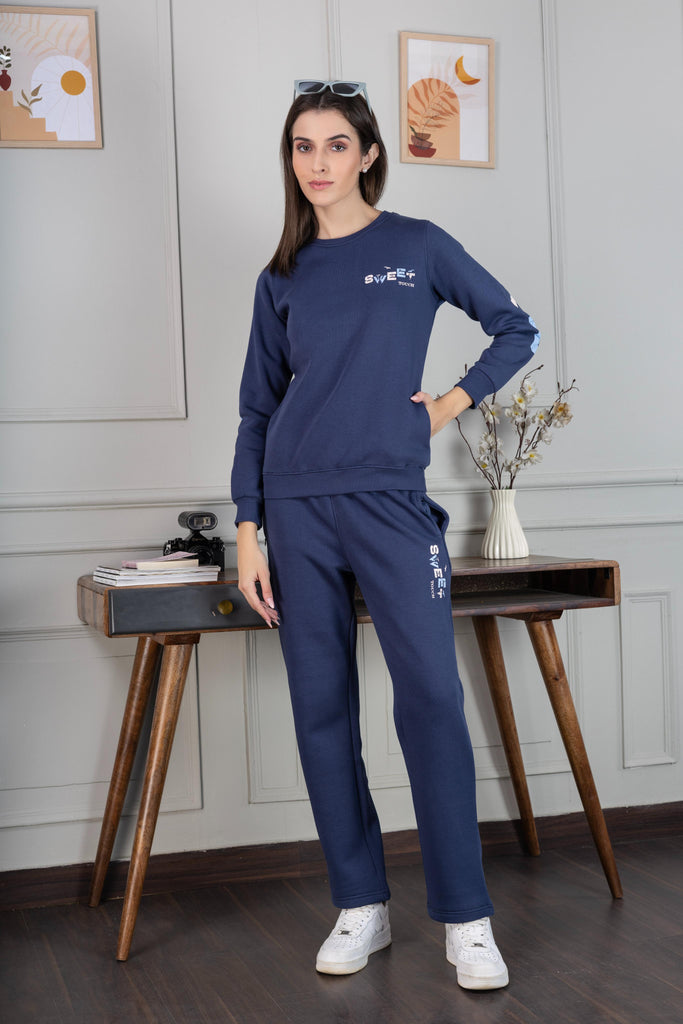 A woman wearing a full sleeve, relaxed fit, fleece co ord set with round neck and back prints in air force Color 