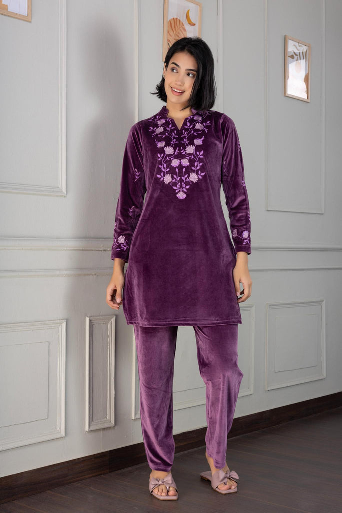 A woman wearing a full sleeve, relaxed fit, velvet night suit with floral embroidery in Purple Color