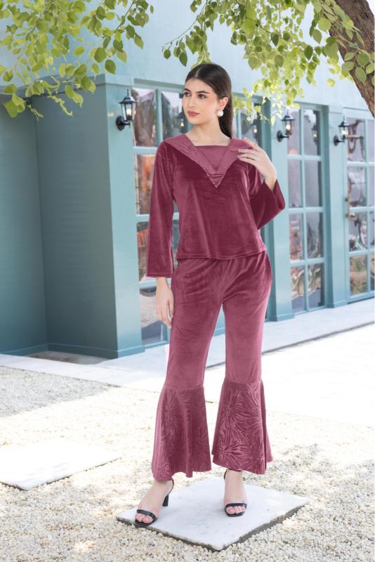 A woman wearing a full sleeve, relaxed fit, Velvet Co-Ord set with V-neck and metallic print at the bottom in  onion Color 